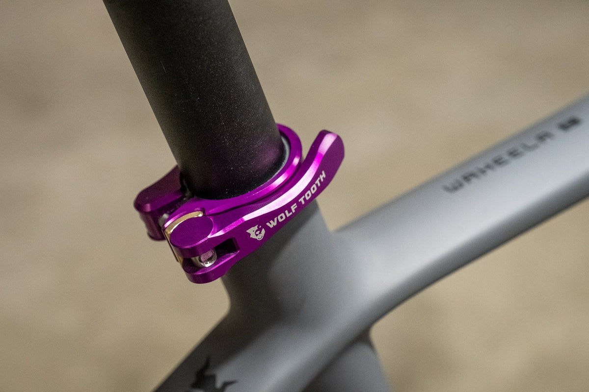 Purple Wolf Tooth Quick Release Seatpost Clamp fitted around the seat tube of a gray frame