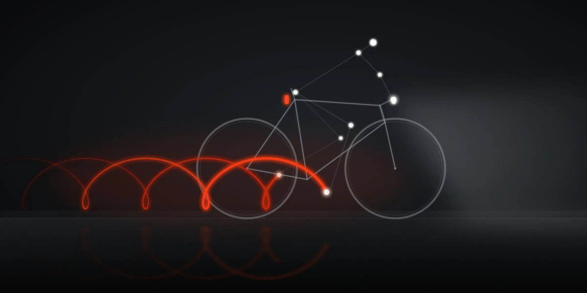 Illustration of a cyclist at night shown as points of light, with red heel light trails looping behind the pedal stroke
