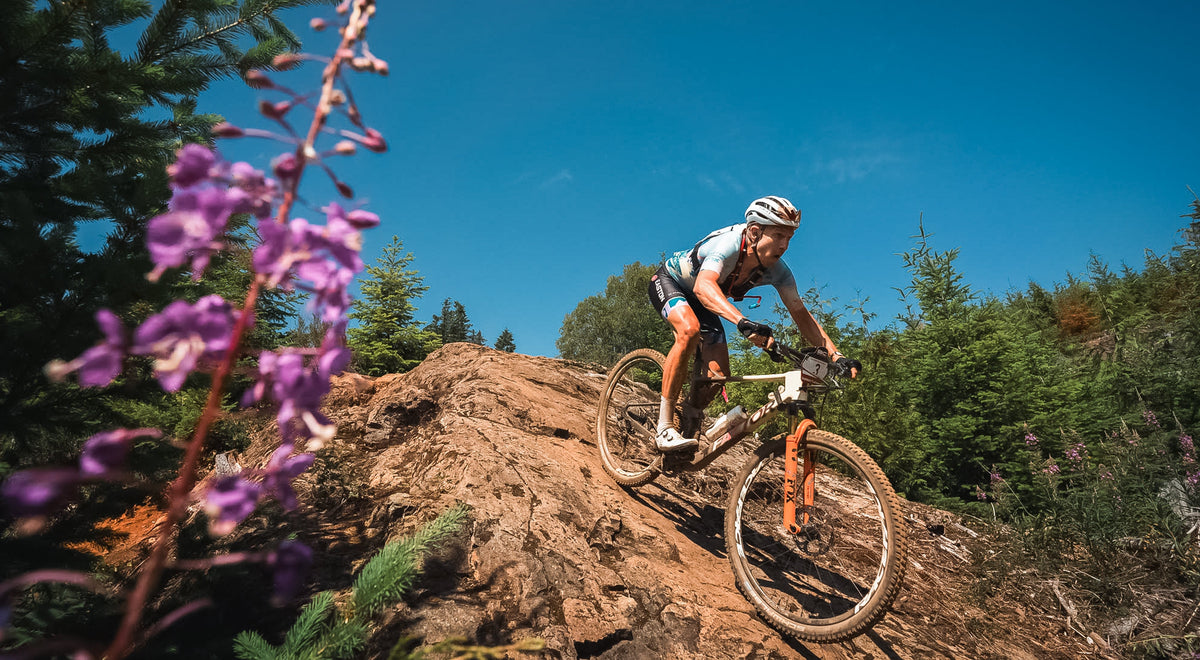 Rider climbing a dirt trail on a Factor LANDO XC mountain bike