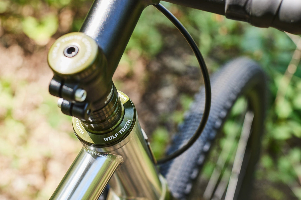 Olive Wolf Tooth headset spacers stacked between the headset and stem on a gravel bike