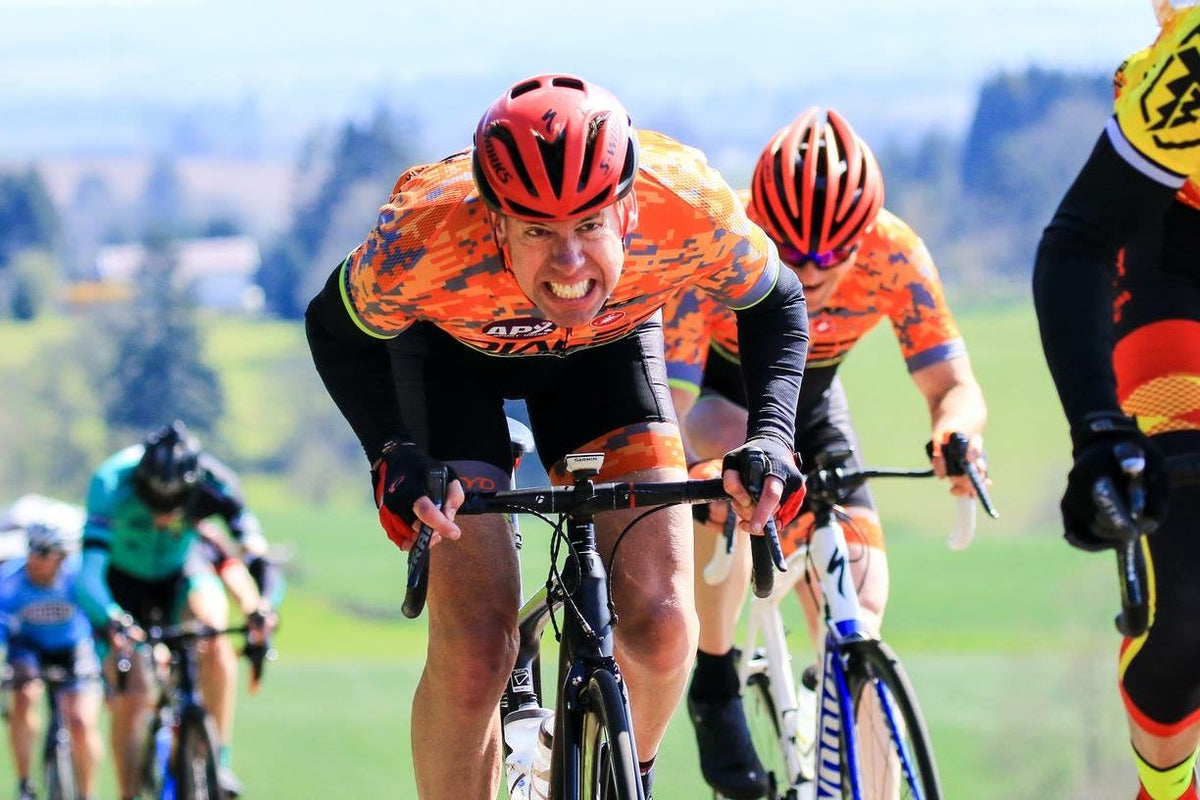 Michael Myers grimacing as he leads teammates up a climb in Dialed Cycling Team kit