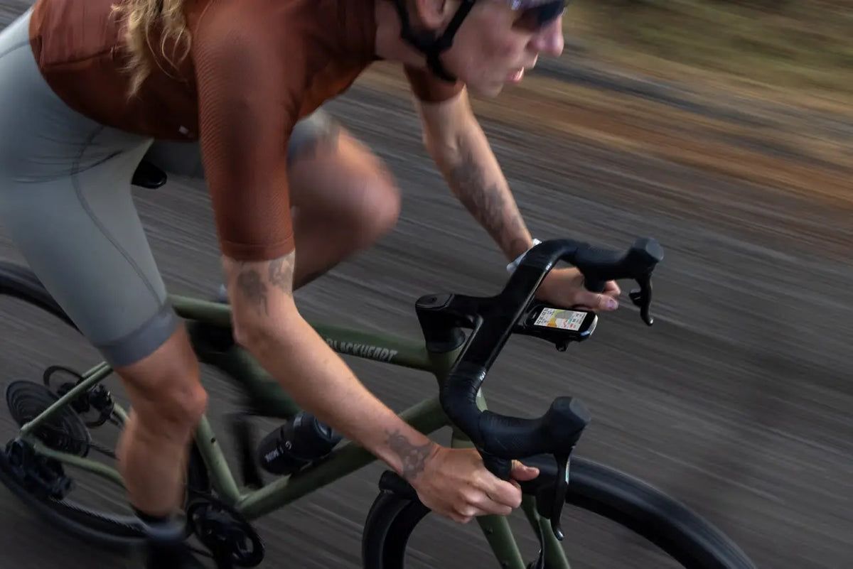 Gravel rider with a Garmin Edge bike computer on the handlebars