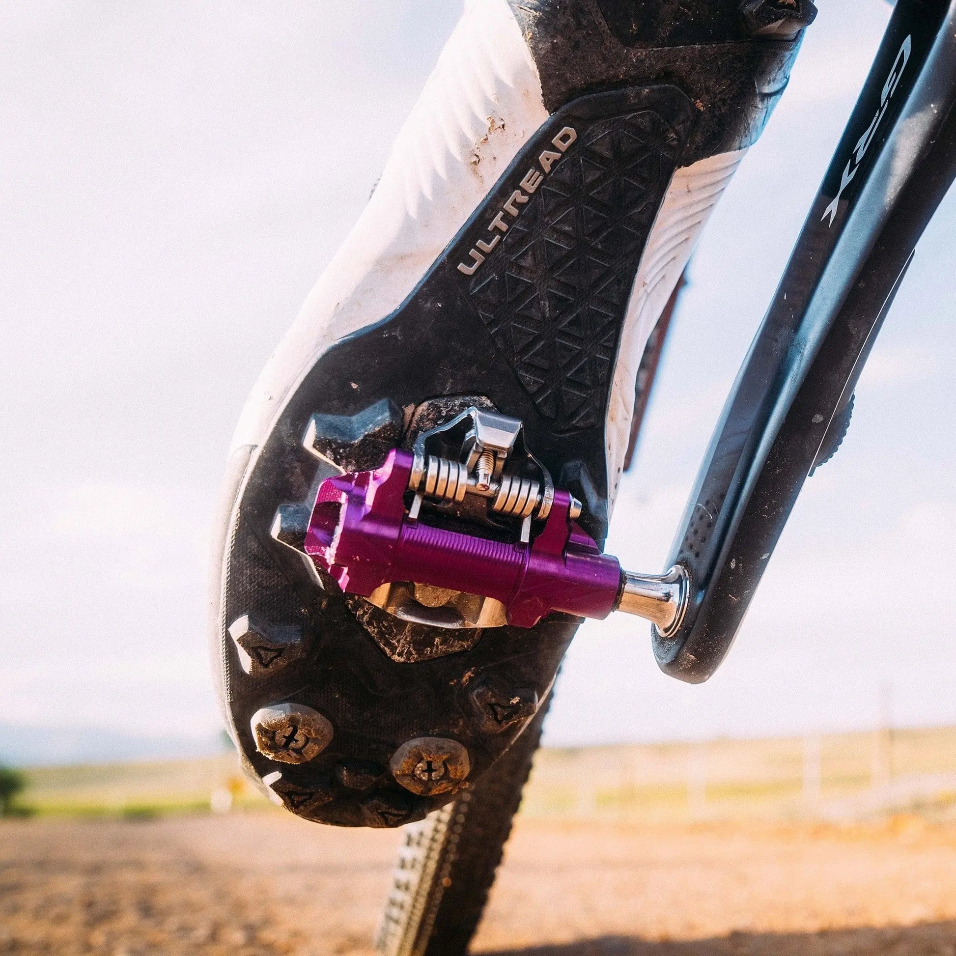 Cyclist riding gravel with Wolf Tooth DEL Gravel Race pedals